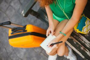donna viaggiatore con arancia valigia, in viaggio in giro mondo foto