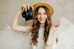 giovane bella sorridente contento donna nel cannuccia cappello Tenere Vintage ▾ foto telecamera