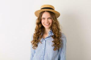 giovane bellissimo elegante donna nel estate stile attrezzatura in posa su bianca parete indossare cannuccia cappello foto