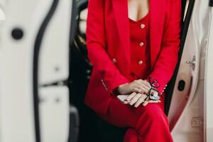 bellissimo sexy ricco attività commerciale donna nel rosso completo da uomo in posa nel bianca auto foto