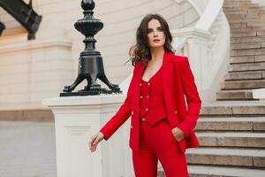 bellissimo sexy ricco attività commerciale stile donna nel rosso completo da uomo a piedi nel città strada, primavera estate moda tendenza foto