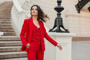 bellissimo sexy ricco attività commerciale stile donna nel rosso completo da uomo a piedi nel città strada, primavera estate moda tendenza foto