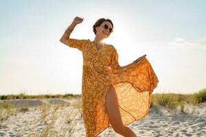 elegante attraente sottile sorridente donna su spiaggia nel estate stile moda tendenza attrezzatura foto