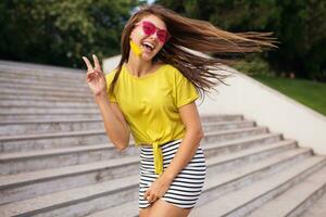 giovane elegante donna avendo divertimento nel città parco, estate stile moda tendenza foto