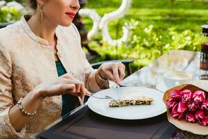 giovane elegante donna seduta nel bar, mangiare gustoso torta foto