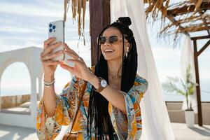 elegante bella donna con africano trecce su soleggiato estate vacanza foto