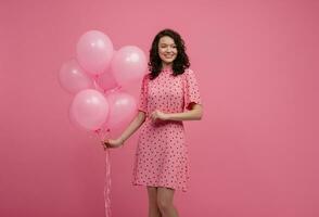 bella giovane donna in posa isolato su rosa studio sfondo con rosa aria baloons foto