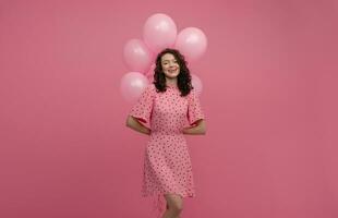 bella giovane donna in posa isolato su rosa studio sfondo con rosa aria baloons foto