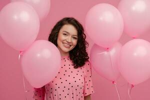 bella giovane donna in posa isolato su rosa studio sfondo con rosa aria baloons foto