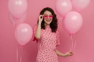 bella giovane donna in posa isolato su rosa studio sfondo con rosa aria baloons foto