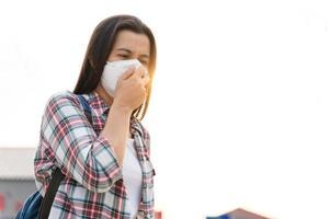 donna asiatica che indossa la maschera n95 per proteggere l'inquinamento pm2.5 e virus. covid-19 concetto di coronavirus e inquinamento atmosferico pm2.5. foto