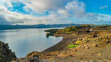 panoramico al di sopra di islandese colorato e selvaggio paesaggio con vulcanico nero sabbia spiaggia a il kleifarvatn lago a estate volta, Islanda foto