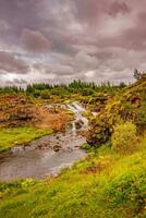 meraviglioso waterfal di nome kermoafoss nel Islanda, nel il città parco di reykjavík, nel autunno colori e drammatico tramonto cielo foto