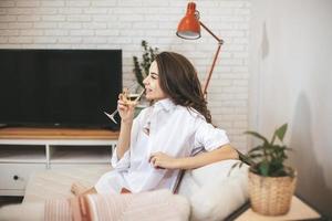 giovane donna con un bicchiere di vino a casa. foto