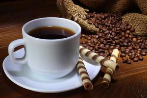 tazza di caffè e chicchi di caffè. bella natura morta foto