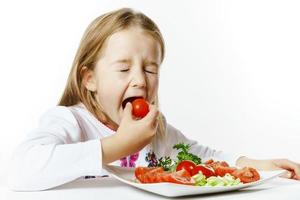bambina carina con piatto di verdure fresche foto