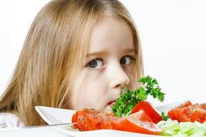 bambina carina con piatto di verdure fresche foto