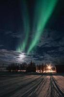 aurora boreale, aurora boreale con stellato nel cielo notturno sopra la chiesa di Flakstad nelle isole lofoten foto