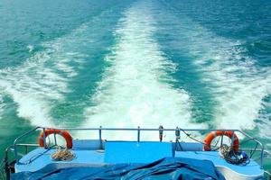 bolle bianche e schizzi di onde sulla poppa del traghetto. vacanza viaggiata in mare. la nave si muoveva veloce in vista dell'oceano e nessuno sul ponte. foto