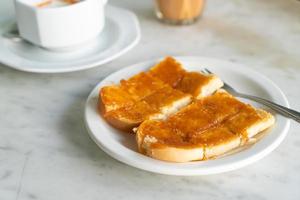 crema pasticcera con pane tostato su piastra bianca foto