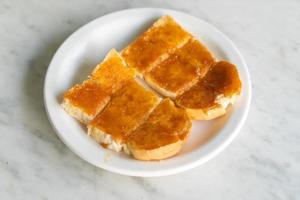 crema pasticcera con pane tostato su piastra bianca foto