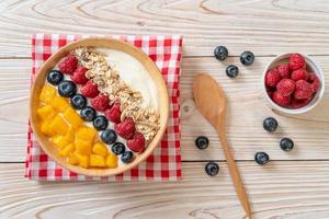 ciotola di yogurt fatta in casa con lampone, mirtillo, mango e muesli - stile alimentare sano foto