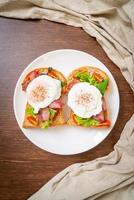 pane integrale abbrustolito con verdure, bacon e uovo o uovo alla Benedict, per colazione foto