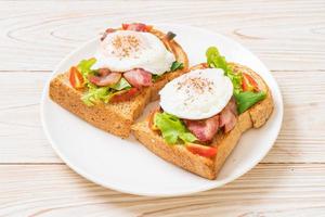 pane integrale abbrustolito con verdure, bacon e uovo o uovo alla Benedict, per colazione foto