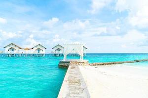 arco bianco con resort tropicale delle Maldive e sfondo del mare foto