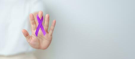 donna Tenere viola nastro per violenza, pancreatico, esofageo, testicolare cancro, alzheimer, epilessia, lupus, sarcoidosi e fibromialgia. consapevolezza mese e mondo cancro giorno concetto foto