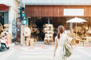 giovane asiatico donna viaggiatore nel vestito con cappello in viaggio per di vimini negozio su chang moi kao strada, turista visitare a il vecchio città nel chang mai, Tailandia. Asia viaggiare, vacanza e estate vacanza concetto foto