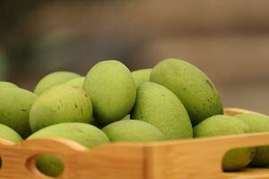 crudo verde Mango su di legno vassoio foto