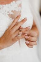 la sposa tocca dolcemente il suo caro anello di fidanzamento foto