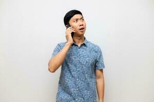 asiatico uomo blu camicia parlando con mobile Telefono isolato foto