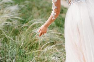 vestire la sposa in un abito da sposa con corsetto e allacciatura foto