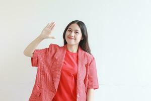 ritratto di bellissimo asiatico donna indossare rosso attrezzatura con contento espressione foto