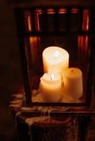 candele accese in una notte buia in una lanterna di legno