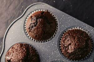 appena al forno cioccolato muffin nel vassoio, fatti in casa comfort cibo ricetta foto