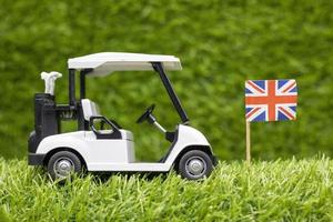 carrello da golf con bandiera union jack sono su sfondo verde erba foto