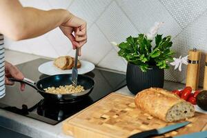 donna cucinando frittata , uso induzione stufa e frittura padella foto