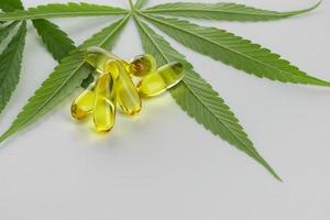 capsule di olio essenziale di cannabis su sfondo bianco. foto