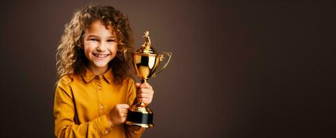 un' vittorioso bambino Tenere un' primo posto trofeo isolato su un' oro pendenza sfondo foto