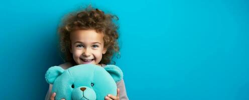 un' bambino stringendo un' comfort giocattolo strettamente isolato su un' blu pendenza sfondo foto