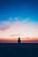 un' bambino guardando a il orizzonte isolato su un' crepuscolo pendenza sfondo foto