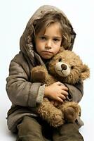 un' solitario bambino abbracciare un' orsacchiotto orso per comfort isolato su un' bianca sfondo foto