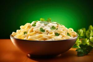 un' acquolina in bocca Immagine di un' cottura a vapore ciotola di cremoso fettuccine Alfredo guarnito con fresco prezzemolo impostato contro un' caldo pendenza sfondo foto