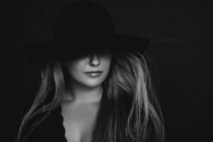 bellissimo bionda donna indossare un' cappello, artistico film ritratto nel nero e bianca per moda campagna e bellezza marca foto