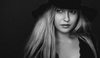 bellissimo bionda donna indossare un' cappello, artistico film ritratto nel nero e bianca per moda campagna e bellezza marca foto