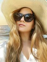 bellezza, estate vacanza e moda, viso ritratto di contento donna indossare cappello e occhiali da sole di il mare, per protezione solare spf cosmetici e spiaggia stile di vita Guarda foto