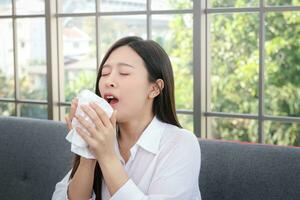 bellissimo donna lungo capelli asiatico malato tosse o starnuti copertina il tuo bocca e naso con fazzoletto di carta carta. concetto di Salute trattamento impedire trasmissione di virus foto